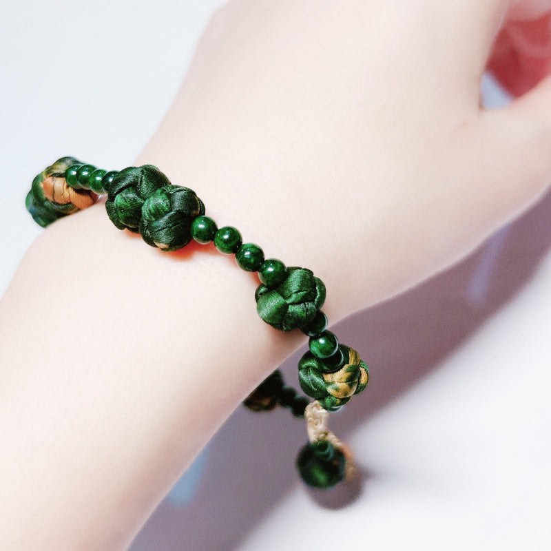 Xiangyunsha silk rose knot bracelet in forest green, wrist detail